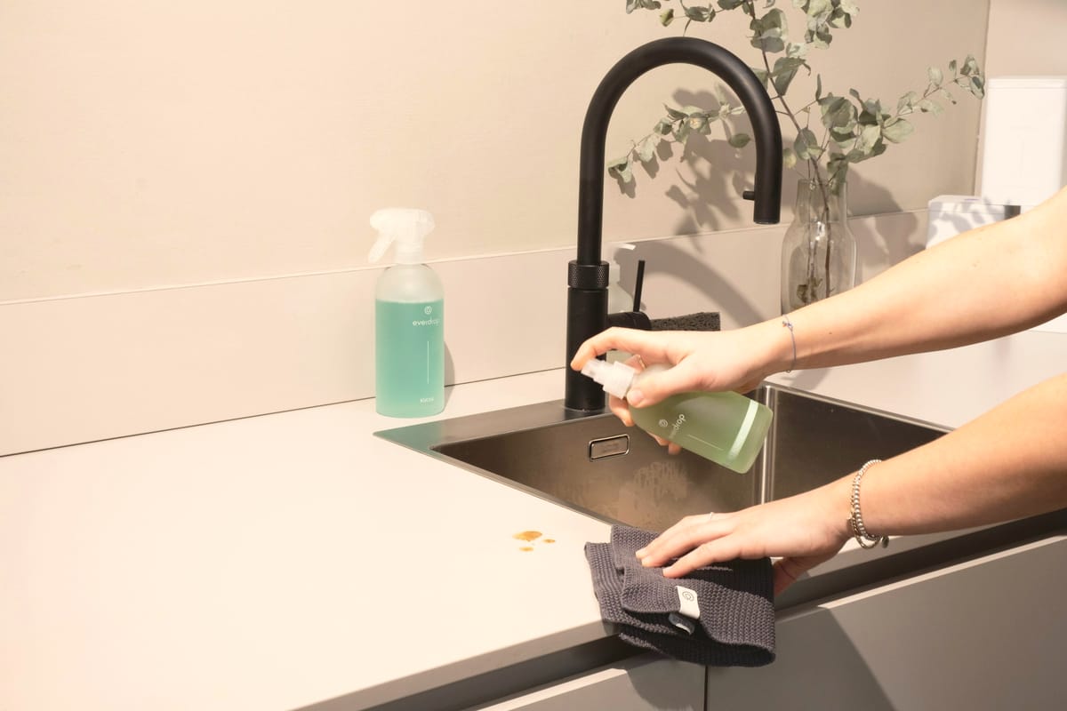 Cleaner wiping a kitchen sink